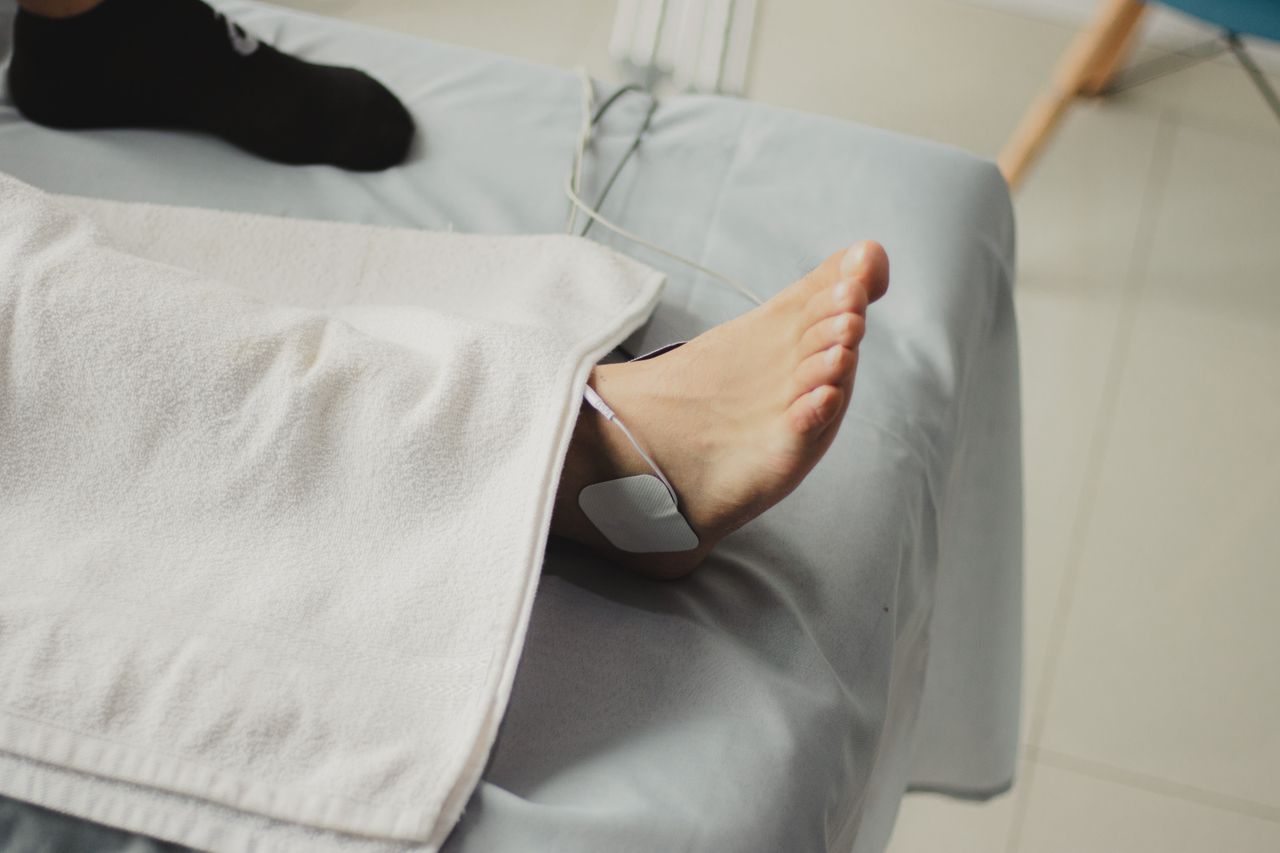 Tjänster A close-up image of a bare foot with a medical electrode, suggesting a healthcare setting.