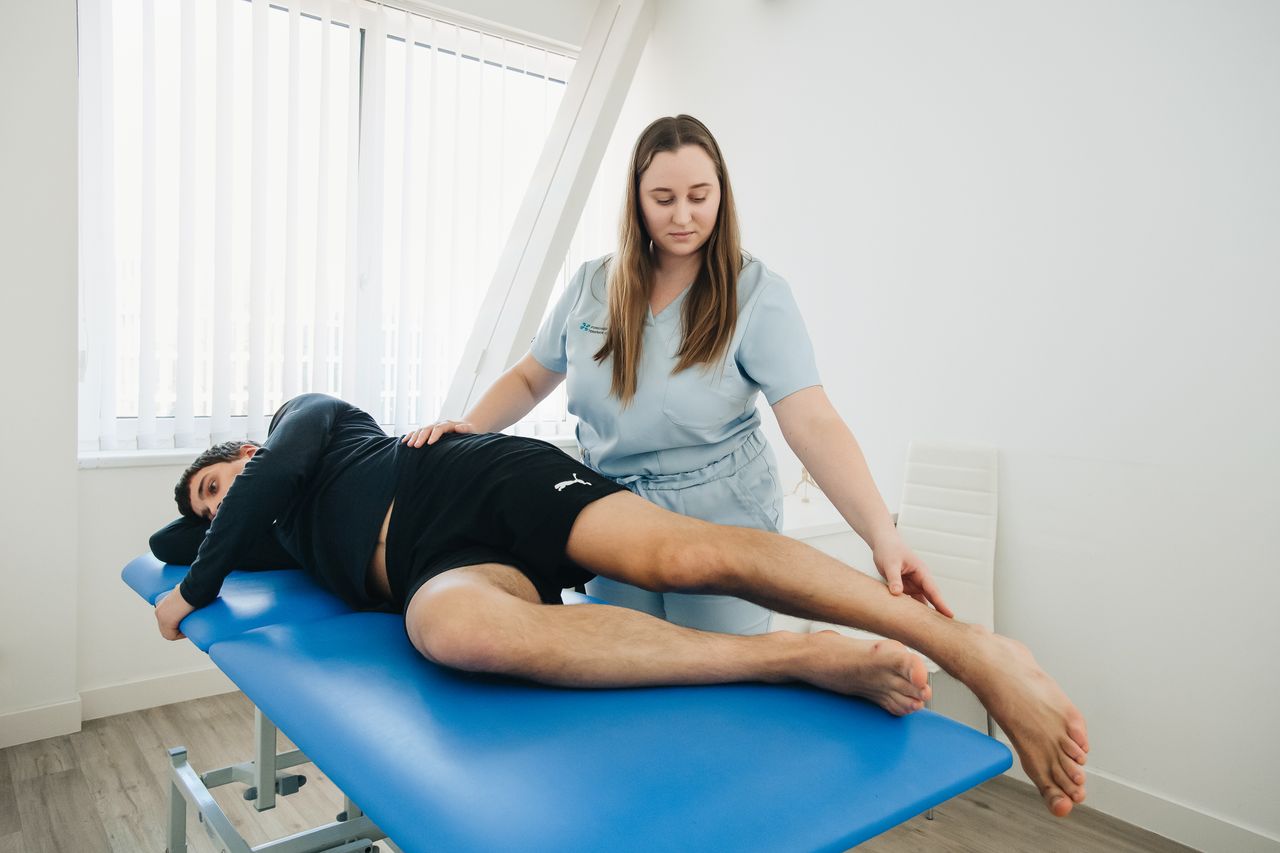 Så hjälper vi dig A physiotherapist assists a patient in a rehabilitation session at a Vilnius clinic.